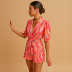 Women’s short summer jumpsuit with vibrant print, built-in belt, and flattering fit for warm days and casual events.